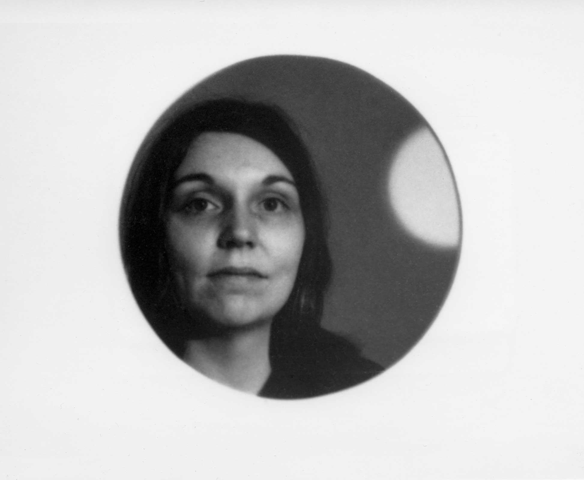 Nancy Holt's face reflected in a circular mirror